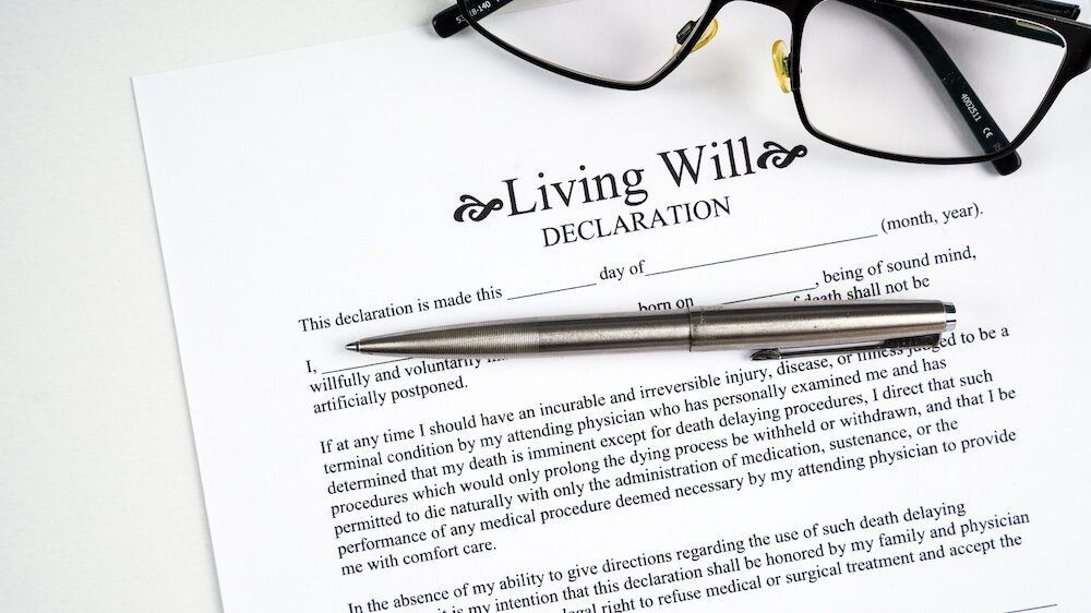 Living will declaration form with glasses and silver pen.